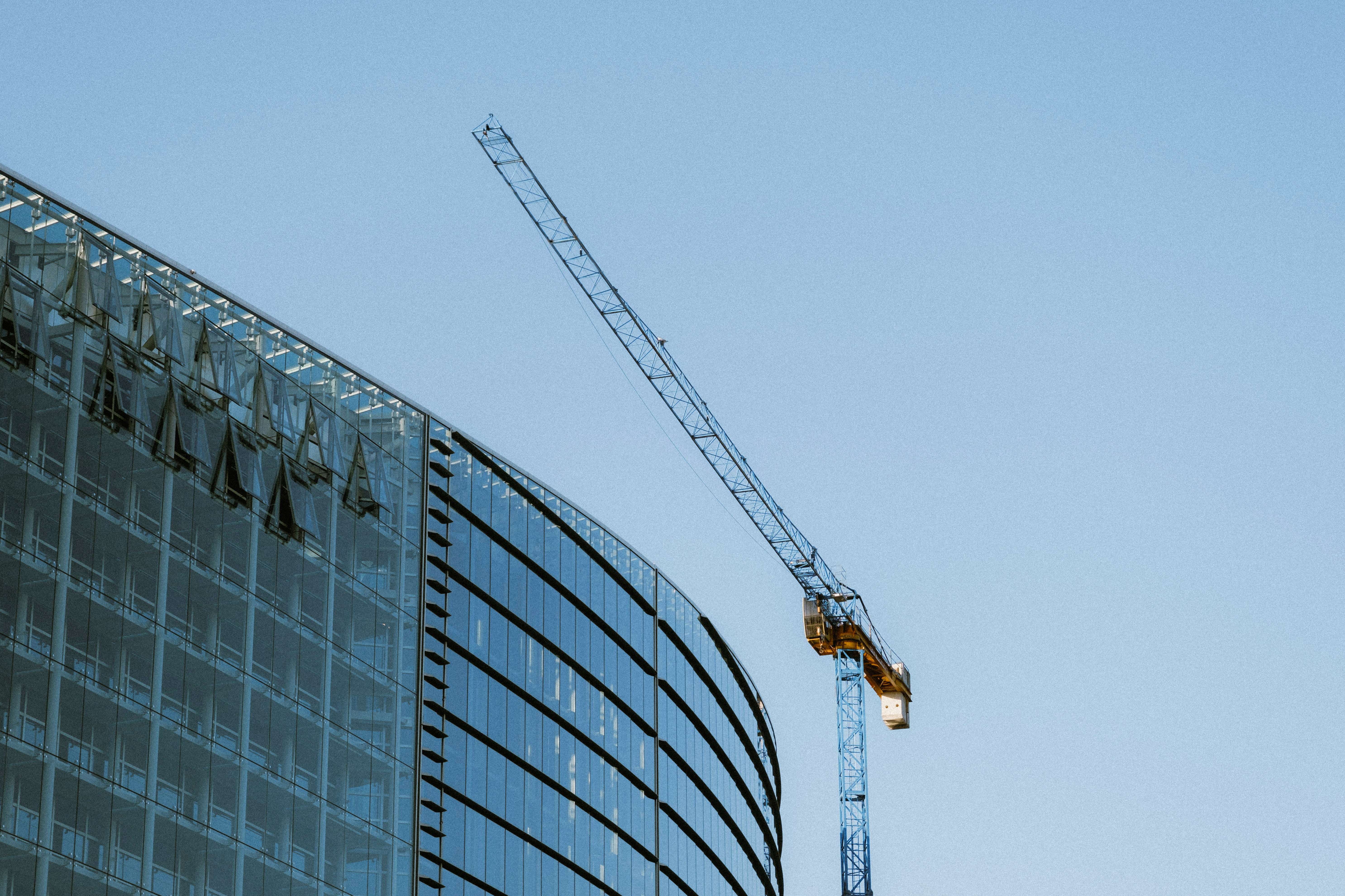 yellow crane near gray building during daytime